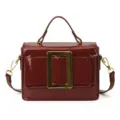 Wine red patent leather handbag featuring a gold square buckle, top handle and strap. - Red