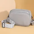 Grey litchi pattern leather crossbody bag with geometric wide strap, stylish minimalist design. - Gray