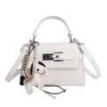 White crocodile texture Kelly handbag for women with cute horse charm and shoulder strap style. - Single Bag / White