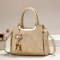 Beigefarbene elegante Handtasche mit Blumenanhänger und mehrlagigem Design im Detail. - Länge 24 Breite 12 Höhe 19 Griff 12cm / Aprikose