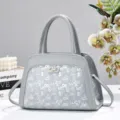 Elegante borsa a mano grigia con motivo monogramma e chiusura metallica raffinata. - Grigio
