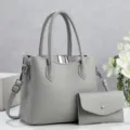 Gedetailleerd overzicht van de elegante grijze lederen handtas met een kleine tas. - Grijs