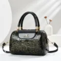 Detail shot of black patent leather handbag showing embossed gold floral pattern and hardware. - L24 W13 H16 Handle 13cm / Gold