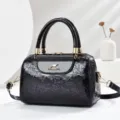 Detailed view of black patent leather embossed floral handbag with gold hardware and dual handles. - L24 W13 H16 Handle 13cm / Purple