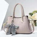 Nahaufnahme der stilvollen grauen Handtasche in Krokooptik mit eleganter Schleife. - L 28 x B 13 x H 19 cm / Gebrochenes Weiß