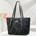 Detailansicht der Damen Camouflage Tragetasche mit Doppelriemen und schicken Metallbeschlägen. - L 29 B 15 H 27 Henkel 25 cm / Schwarz