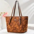 Detailansicht der braunen Camouflage-Tasche mit doppelten Henkeln und modischen Schnallen. - L 29 B 15 H 27 Henkel 25 cm / Erdgelb