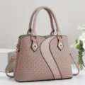 Detailed view of stylish taupe handbag featuring woven texture panels, metal rings, and dual handles. - Khaki