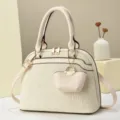 Beige textured dome shoulder bag with top handles, crossbody strap and cute mini hanging pouch. - L 29 W 13 H 21 Handle 14 cm / White