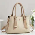 Detailansicht der eleganten Handtasche aus Beigecanvas mit braunen Ledergriffen und Metallschmuck. - 28x12x20cm (Griff 15cm) / Khaki