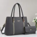 Graues Leder Handtaschen-Set Detail mit hochwertiger Textur und edlen goldenen Beschlägen. - Grau