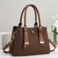 Vista dettagliata della elegante borsa da donna marrone con doppi manici e dettagli dorati. - 28x12x20cm (Manico 15cm) / Caffè