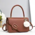 Vue détaillée du sac bandoulière en cuir marron avec poignée tressée et boucle. - Jaune Terre
