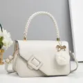 Elegante weiße Umhängetasche mit geflochtenem Griff, moderner Schnalle und edlem Perlenanhänger. - Weiß