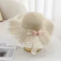 Detailansicht des eleganten beigen Strohhuts mit feiner weißer Spitzenborte und Rosen. - M (56-58cm) / Beige