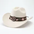 Detailansicht eines stilvollen Western-Cowboyhuts mit besticktem braunem Band und Vintage-Metallschnalle. - M (56-58cm) / Beige