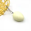 Portachiavi con uovo di Pasqua vista di dettaglio con uovo giallo nel piccolo cestino. - Giallo
