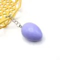 Primo piano del portachiavi con ciondolo a forma di uovo di Pasqua viola e catena in metallo. - Viola