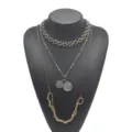 Vue détaillée du collier superposé multicouche avec chaînes en métal contrastées et pendentifs. - Or + Blanc K