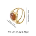 Detail view of a bold geometric gold-tone hinged bangle featuring an amber-colored resin stone. - Geometric Resin Texture Bracelet (B3984)