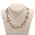 Primo piano dettagliato della collana con gocce di strass e cristalli scintillanti dorati. - Collana / Bianco