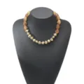 Detail view of the vintage irregular resin and gold beaded clavicle necklace, elegant colorblock design. - Amber