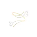 Close up detail of gold open cuff bracelet featuring white enamel double hearts and fine wire. - Heart Style / White