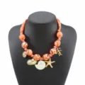 Chic ocean style orange fabric beaded necklace featuring cute seashell and starfish pendants. - Orange