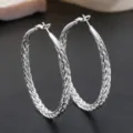 Zilverkleurige gevlochten creolen detailopname, stijlvol gestructureerd geometrisch sieradenontwerp. - 60mm Stijl / 60mm 925 Zilver Kleur