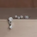 Detailopname van een minimalistische koperen oorbellen set met strass, heel elegant. - 3-delige Set Stijl 4 Witte Strass / Witgoud