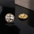 Close-up detail opname van ronde zirkonia oorknopjes met glinsterende baguette stenen. - Witte Zirkonia / 18K Verguld