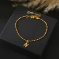 Goudkleurige kralenketting armband voorzien van een beginletter N hanger voor vrouwen. - Letter N