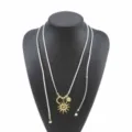 Detalle del collar largo bohemio con colgante dorado de sol y luna en cordón blanco. - Blanco