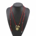 Largo collar bohemio de terciopelo rojo con colgantes de sol y luna dorados, estilo vacacional. - Rojo