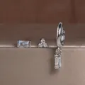 Gedetailleerde close-up van de elegante koperen oorbellen set met sprankelende stenen. - 3-delige Set Stijl 2 Witte Strass / Witgoud