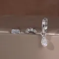 Gedetailleerd overzicht van een driedelige koperen oorbellen set met zirkonia stenen. - 3-delige Set Stijl 3 Witte Strass / Witgoud