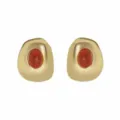 Detailed close-up shot of irregular geometric gold-tone earrings featuring red cracked stone inlay. - E14540