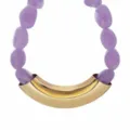 Macro detail view of purple resin beads paired with a curved gold accent statement collar. - Purple