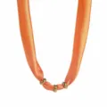 Detail of orange fabric silk scarf necklace featuring shiny gold metal rings, unique design style. - Orange