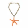 Close-up detail of the chunky gold chain necklace featuring a large vibrant orange resin starfish. - Orange