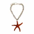 Detailed view of the resin starfish pendant on a gold chain, ocean vacation style jewelry. - Red
