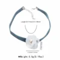 Denim choker necklace view highlighting the white fabric flower and pearl pendant. - White