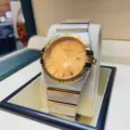 Edler Edelstahl-Quarzuhr in Bicolor mit römischen Ziffern, goldfarbenem Zifferblatt und Datum. - Herren / Bicolor Goldenes Zifferblatt