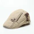 Detailansicht der khakifarbenen Schiebermütze mit Totenkopf-Charm, Stickerei und Kontrastnähten. - M (56-58cm) / Beige