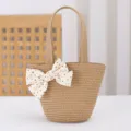 Detalle del bolso de paja para niños con un lindo lazo de lunares, estilo de verano. - Caqui