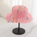 Close-up detail of the pink flat top straw hat featuring colorful paint splash graffiti design. - M (56-58cm) / Hot Pink