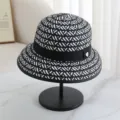 Detailed view of a black and white woven fisherman hat with black ribbon and heart charm. - M (56-58cm) / Black