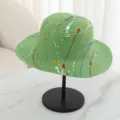 Close-up detail of green straw hat with colorful paint splatter design for summer outdoor wear. - M (56-58cm) / Green