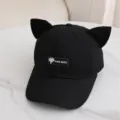 Vista detallada de la gorra negra con orejas de gato y etiqueta delantera hecha a mano. - Talla Única para Adultos / Negro