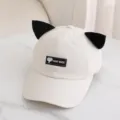 Primer plano de bonita gorra de béisbol beige con orejas de gato y parche negro. - Talla Única para Adultos / Beige